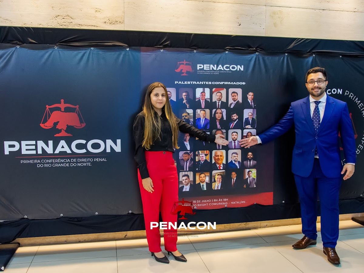 Dois participantes diante do painel da I PENACON